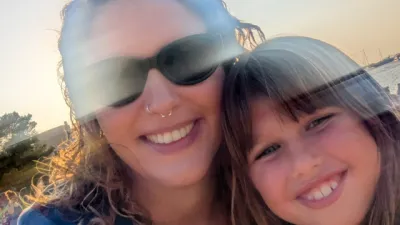 A mother and daughter smile in a faded photo.